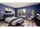 Virtually staged main bedroom with plush bed, accent chair, and large window at 1711 S Blackhawk Way # D, Aurora, CO 80012