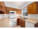 Clean kitchen with wood cabinets, white appliances, and a dishwasher at 1711 S Blackhawk Way # D, Aurora, CO 80012