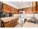 Galley kitchen with wood cabinets and appliances at 1711 S Blackhawk Way # D, Aurora, CO 80012