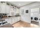 White kitchen featuring granite counters, white cabinets, and hardwood floors at 3445 N Clay St, Denver, CO 80211