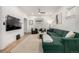 Comfortable living room featuring a green sectional, TV, and hardwood flooring at 3445 N Clay St, Denver, CO 80211