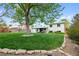 Large backyard with mature trees, lush lawn, and a stone pathway at 4525 S Cole Ct, Morrison, CO 80465