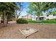 Backyard area with a small sandbox and mature trees, partially covered in mulch at 4525 S Cole Ct, Morrison, CO 80465