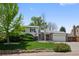 Charming home with manicured lawn, mature trees, and brick accents offers great curb appeal at 4525 S Cole Ct, Morrison, CO 80465