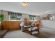 A comfortable living room features a brick fireplace, and outdoor views at 4525 S Cole Ct, Morrison, CO 80465