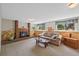 Cozy living room with a brick fireplace, wainscoting, and bright windows at 4525 S Cole Ct, Morrison, CO 80465