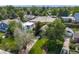 An aerial view showcases the home nestled amongst lush trees with a manicured lawn in a serene neighborhood at 1765 Xenia St, Denver, CO 80220