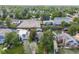 An aerial view displays the home nestled among mature trees, neighboring houses, and lush greenery in a quiet neighborhood at 1765 Xenia St, Denver, CO 80220