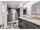 Bathroom featuring a double vanity with granite counters and modern tiled shower at 1765 Xenia St, Denver, CO 80220