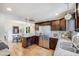 Spacious kitchen with stainless steel refrigerator, granite countertops, and dark wood cabinets at 1765 Xenia St, Denver, CO 80220