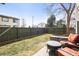 Fenced backyard with a stone firepit, grass, and furniture, perfect for entertaining at 3471 S Ammons St # 12-6, Lakewood, CO 80227