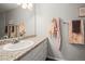 Cozy bathroom featuring a granite-look countertop, large mirror, and soft, warm colored towels at 3471 S Ammons St # 12-6, Lakewood, CO 80227