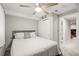 Comfortable bedroom with ceiling fan, plush bed, and view into the en suite bathroom at 3471 S Ammons St # 12-6, Lakewood, CO 80227