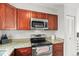 A lovely kitchen featuring granite countertops, stainless steel appliances, and cherry cabinets at 3471 S Ammons St # 12-6, Lakewood, CO 80227