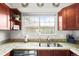 Kitchen view with stainless steel sink and granite countertops, overlooking the backyard through a window at 3471 S Ammons St # 12-6, Lakewood, CO 80227