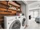 Convenient laundry room with wood accent wall and front load washer and dryer near the bedroom at 3471 S Ammons St # 12-6, Lakewood, CO 80227