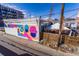 Exterior shot of the building with a mural and outdoor tented eating area at 2901 Wyandot St # 18, Denver, CO 80211