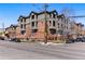 Brick apartment building featuring multi-level balconies on a corner lot with metered street parking and bare trees under a clear blue sky at 2901 Wyandot St # 18, Denver, CO 80211