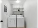 A clean laundry room with white washer and dryer, and overhead storage shelves at 2901 Wyandot St # 18, Denver, CO 80211