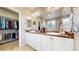 Stylish bathroom with dual sinks, elegant mirrors, and walk-in closet access, offering convenience and functionality at 5280 Longs Peak St, Brighton, CO 80601
