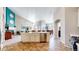 Open-concept kitchen with island, stainless steel appliances, and seamless flow to the living and dining areas at 5280 Longs Peak St, Brighton, CO 80601
