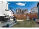 A serene backyard with a patio dining set, lounge chair, well-maintained lawn, and wooden fence offers relaxation at 9690 E 5Th Ave, Denver, CO 80230