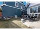 Spacious backyard with green grass, patio with dining set, lounge chair, grill, and a dark blue exterior at 9690 E 5Th Ave, Denver, CO 80230