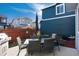 A beautiful backyard featuring outdoor dining set, grill, and a blue house exterior, perfect for gatherings at 9690 E 5Th Ave, Denver, CO 80230
