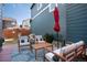 Backyard featuring stylish outdoor seating with plush cushions, a wood table, a red umbrella, and a patterned rug for relaxation at 9690 E 5Th Ave, Denver, CO 80230