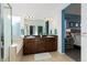 Bathroom with dual vanity sinks, a large mirror, and a glass-enclosed shower/tub at 9690 E 5Th Ave, Denver, CO 80230