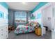 This bedroom has bright, striped walls, a large window, and a colorful surfboard pattern comforter at 9690 E 5Th Ave, Denver, CO 80230