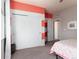 Bright bedroom featuring striped walls, sliding closet doors, and cozy carpet at 9690 E 5Th Ave, Denver, CO 80230