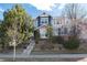 Charming two-story home featuring a well-maintained front yard and inviting entrance with decorative trees and brickwork at 9690 E 5Th Ave, Denver, CO 80230