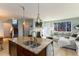 Open-concept kitchen and living area with granite countertops, stainless steel appliances, and a comfortable seating area at 9690 E 5Th Ave, Denver, CO 80230