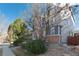 Side view of a two-story home featuring light gray siding and a well-maintained yard with mature trees and garden at 9690 E 5Th Ave, Denver, CO 80230