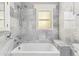 Luxurious bathroom featuring marble tile, a deep soaking tub, and modern fixtures, designed for relaxation and comfort at 761 N Lafayette St, Denver, CO 80218