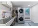 Functional laundry room with modern, stackable washer and dryer, utility sink, and ample storage space at 761 N Lafayette St, Denver, CO 80218