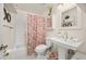 Neat bathroom featuring a pedestal sink, patterned shower curtain, and white tile at 2871 Humboldt Cir, Longmont, CO 80503