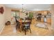 Cozy dining area with a wooden table, chandelier, and hardwood floors adjacent to the kitchen at 2871 Humboldt Cir, Longmont, CO 80503