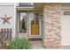 Inviting front door framed by brick and a decorative star, enhancing the home's curb appeal at 2871 Humboldt Cir, Longmont, CO 80503