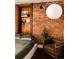 Bedroom with exposed brick, wooden shelving, and a cozy chair at 701 W 6Th Ave, Denver, CO 80204