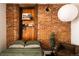 Bedroom with exposed brick, wooden shelving, and a cozy chair at 701 W 6Th Ave, Denver, CO 80204