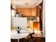 Well-lit kitchen with light wood cabinets, tiled backsplash, and dining area at 701 W 6Th Ave, Denver, CO 80204