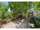 Landscaped backyard featuring a stone patio, mature trees, and privacy fence at 8060 Meadowdale Sq, Niwot, CO 80503