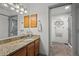 Bathroom featuring granite countertops, wooden cabinets, and a shower behind a sliding glass door at 8060 Meadowdale Sq, Niwot, CO 80503