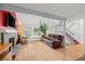 Open-concept living room with hardwood floors, a brick fireplace, and large windows overlooking the front yard at 8060 Meadowdale Sq, Niwot, CO 80503