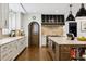 Bright kitchen featuring white cabinets, stainless steel appliances, a large island, and hardwood floors at 2500 S Clayton St, Denver, CO 80210