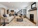 Bright living room featuring a cozy fireplace, neutral furnishings, staircase, and an open layout at 2500 S Clayton St, Denver, CO 80210