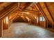 Unfinished attic space with exposed wood beams and a window, provides room for storage or renovation at 101 Glenmoor Ln, Cherry Hills Village, CO 80113