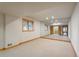 Finished basement space featuring wall mirror, neutral carpet, and wood trim with an additional room beyond at 101 Glenmoor Ln, Cherry Hills Village, CO 80113